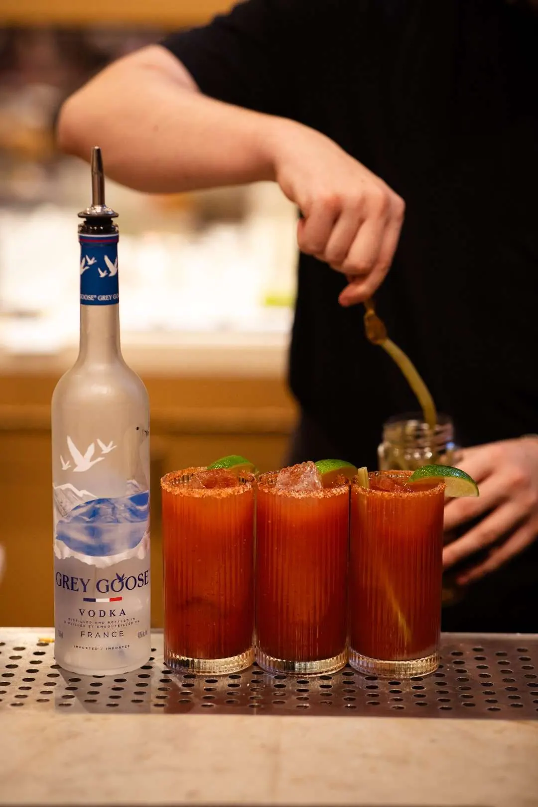 Bartender garnishing Caesars at the bar